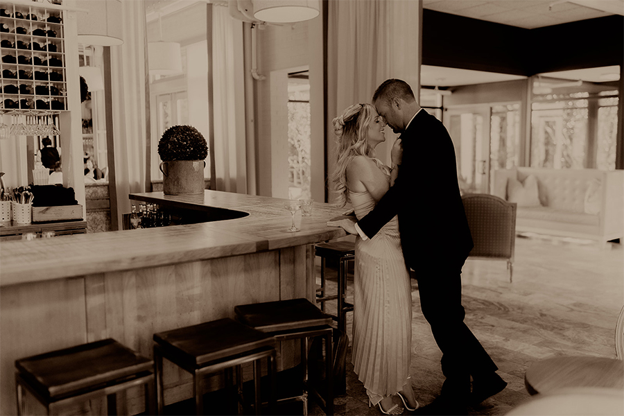 Warm toned black and white photo of couple romantically gazing into each other's eyes in Print Works Bistro.
