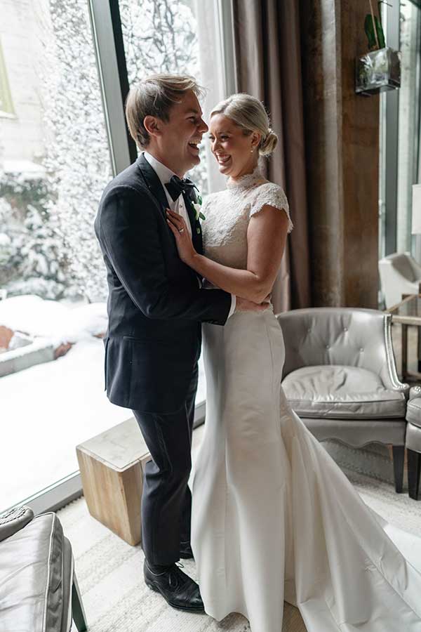 Katie and Sam | Photo by Griffin Hart Davis Photography The bride and groom share a laugh in the social lobby in front of Proximity Hotels 22 foot windows.