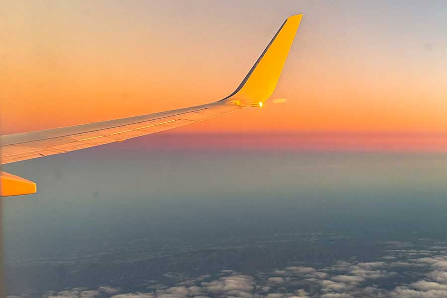 Fly from PTI View from window seat on airplane as sun is setting.